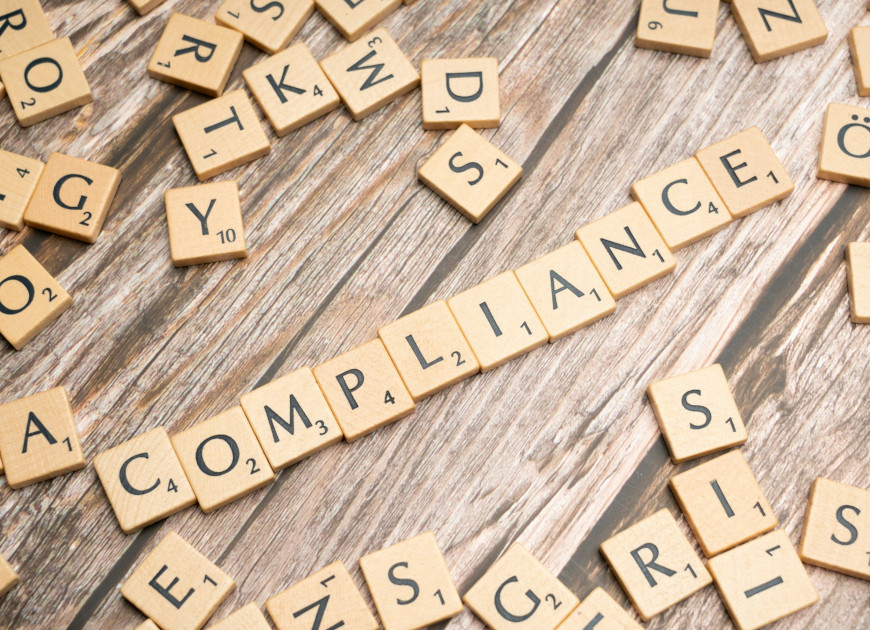 Scrabble tiles spelling out the word compliance